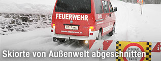 Feuerwehrauto f&auml;hrt auf verschneite, gesperrte Stra&szlig;e