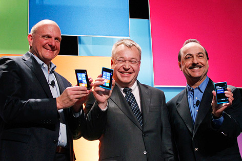 Steve Ballmer von Microsoft, Stephen Elop von Nokia und Ralph de la Vega von AT&T mit Mobil-Telefonen