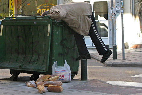 © AP/Nikolas Giakoumidis Mann in Thessaloniki holt altes Brot aus Abfalltonne