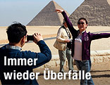Eine Touristin wird vor Pyramiden fotografiert