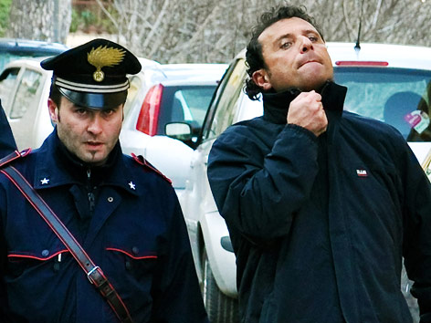 Schiffskapitän der  "Costa Concordia", Francesco Schettino und ein Polizist
