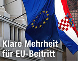 Kroatische und EU-Flagge hängen nebeneinander an einem Haus