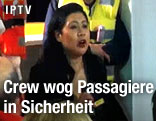 Ein Crewmitglied der "Costa Concordia" spricht mit Passagieren in Schwimmwesten