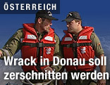 Zwei Einsatzkräfte auf einem Motorboot auf der Donau