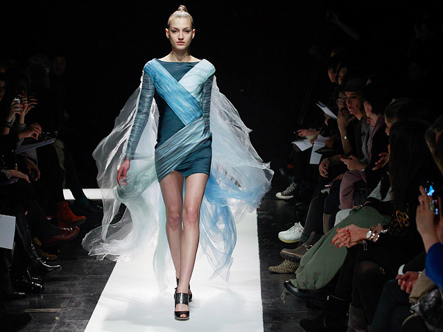 © APA/EPA/Ian Langsdon Ein Model trägt ein kurzes Kleid mit weitem Schal von Maxime Simoens