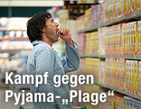 Mann im Pyjama steht im Supermarkt