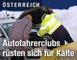 Ein ÖAMTC-Pannenfahrer sieht gemeinsam mit einer Frau in den Motorraum eines Autos