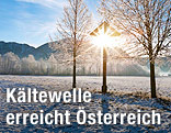 Sonnenbeschienene Winterlandschaft mit Bergen im Hintergrund