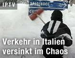 Mann kehrt verschneite Verkehrstafel ab