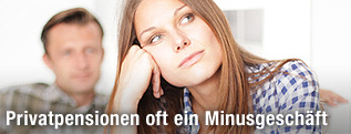 Frau und Mann sitzen nachdenklich auf dem Sofa