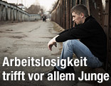 Jugendlicher sitzt am Straßenrand