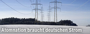 Stromleitungen über schneebedeckter Landschaft