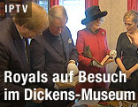 Prinz Charles und seine Frau Camilla begutachten Originalschriftstücke des Schriftstellers Charles Dickens