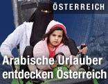 Arabische Frau mit Kind auf einer Sommerrodelbahn