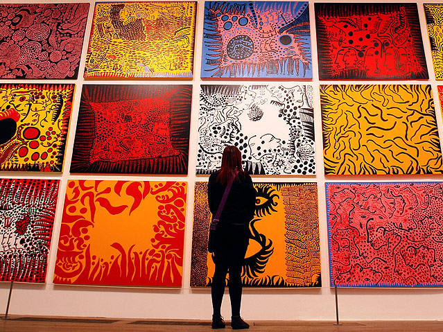 © AP/Kirsty Wigglesworth Eine Frau blickt auf ein riesiges Gemälde von Yayoi Kusama