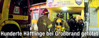 Feuerwehrmänner vor dem Eingang eines Gefängnisses