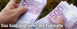 Hände mit mehreren 500-Euro-Scheinen