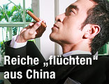 Reicher chinesischer Mann mit Zigarre in einem Club