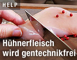 Frau schneidet eine Hühnerbrust auf