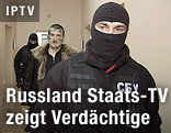 Vermummter Polizist mit Terrorverdächtigem