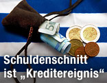Geldbeutel mit Scheinen und Münzen auf einer griechischen Flagge