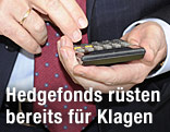 Mann hält Taschenrechner in der Hand