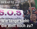 Syrische Demonstranten halten ein S.O.S.-Banner in der Hand