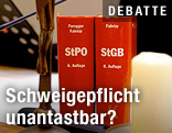 Strafprozessordnung und Strafgesetzbuch auf einem Richtertisch im Gericht