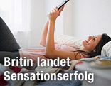 Eine Frau liest ein E-Book im Bett