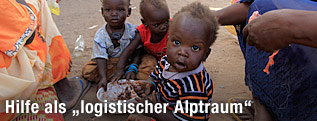 Kinder im Sudan sitzen am Boden und essen