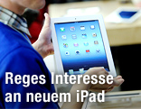Verkäufer hält das neue Apple iPad in die Kamera