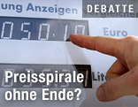 Ein Finger zeigt auf einen Spritpreis auf einer Zapfsäule