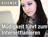 Lächelnde, junge Frau vor dem Laptop