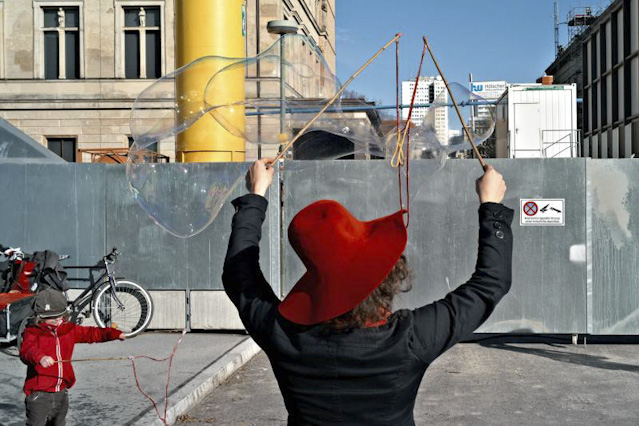 © Andreas Stelter Straßenszene mit Frau, die Seifenblasen macht