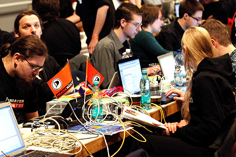 © dapd/Mario Vedder Personen sitzen an einem Tisch mit Laptops, vielen Kabeln und Wimpeln der Piratenpartei