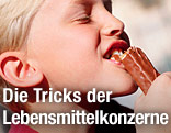 Bub beißt in einen Schokoriegel