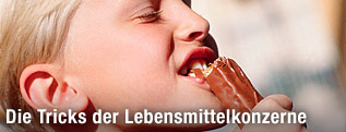 Bub beißt in einen Schokoriegel