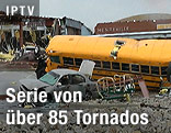 Besch&auml;digter Schulbus, zerdr&uuml;cktes Auto und Geb&auml;udesch&auml;den nach einem Tornado