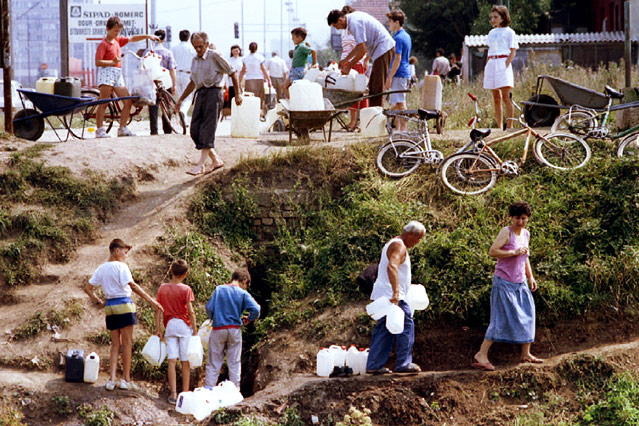 Zivilisten sammeln Trinkwasser in Kanistern