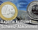 Euro-Münze neben einer Schweizer Franken-Münze mit Franken-Scheinen im Hintergrund