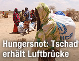 Frau in der Sahelzone mit UNHCR-Hilfspaket