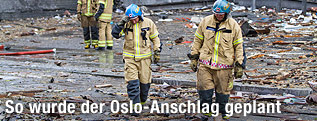 Feuerwehrleute gehen &uuml;ber Tr&uuml;mmerhaufen