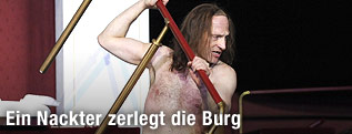 Joachim Meyerhoff hält als "Robinson Crusoe" im Burgtheater ein abmontiertes Geländer in der Hand