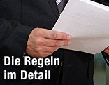Mann hält Papierzettel in der Hand