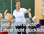 Eine unterrichtende Lehrerin steht vor der Tafel