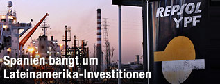 Schild mit der Aufschrift "Repsol YPF" vor einer Raffinerie
