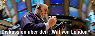 Mann mit Headset und Tablet vor Monitoren in der New Yorker Börse