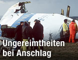 Ermittler neben einem zerstörten Flugzeugteil von Pan Am Flug 103 im Jahr 1988