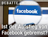 Das Logo von Facebook durch eine Lupe gesehen