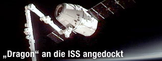 Der Raumtransporter „Dragon“ dockt an dem Arm der Internationalen Raumstation (ISS) an